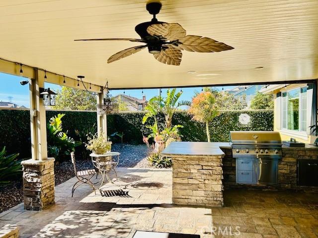 view of patio with an outdoor kitchen and a grill