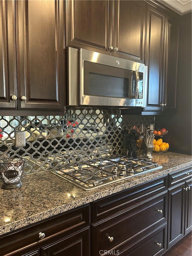 kitchen with stainless steel appliances, tasteful backsplash, and dark brown cabinets