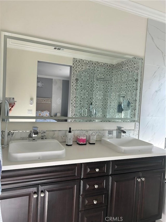 bathroom with vanity, crown molding, and decorative backsplash