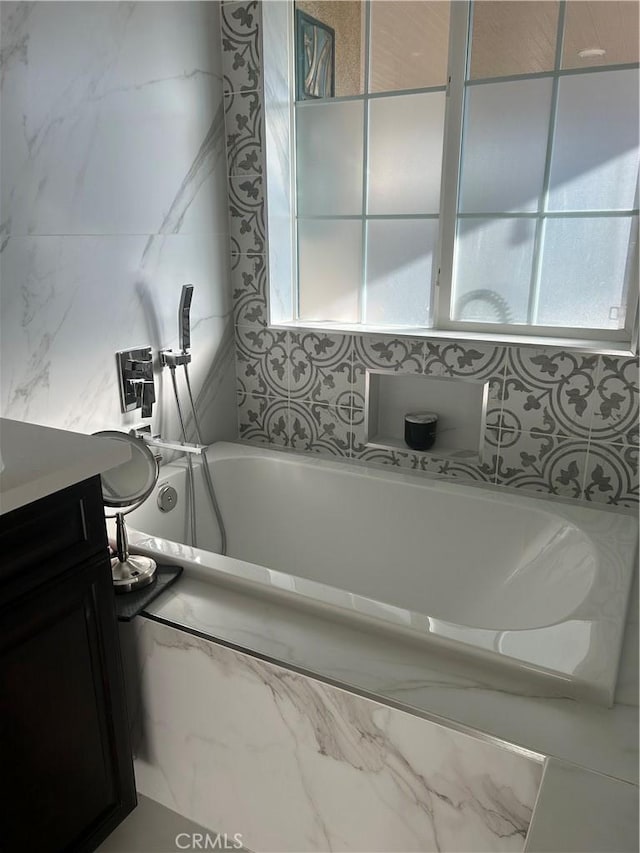 bathroom with vanity and a relaxing tiled tub