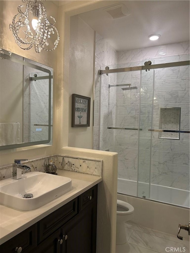 full bathroom with an inviting chandelier, vanity, toilet, and combined bath / shower with glass door