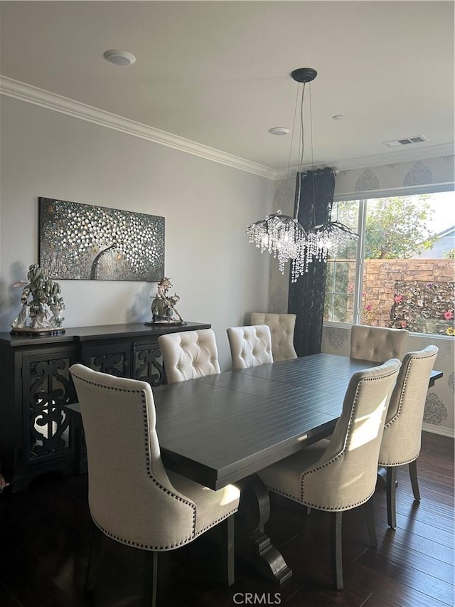 dining space with dark hardwood / wood-style flooring, crown molding, and an inviting chandelier