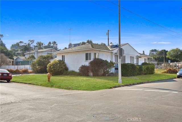 view of front of property with stucco siding and a front lawn