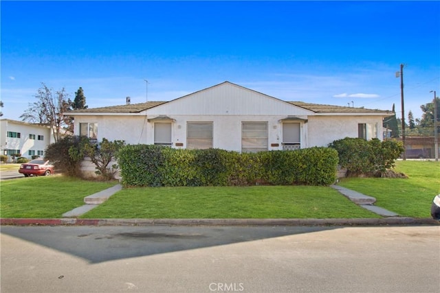 view of front of house featuring a front lawn and stucco siding