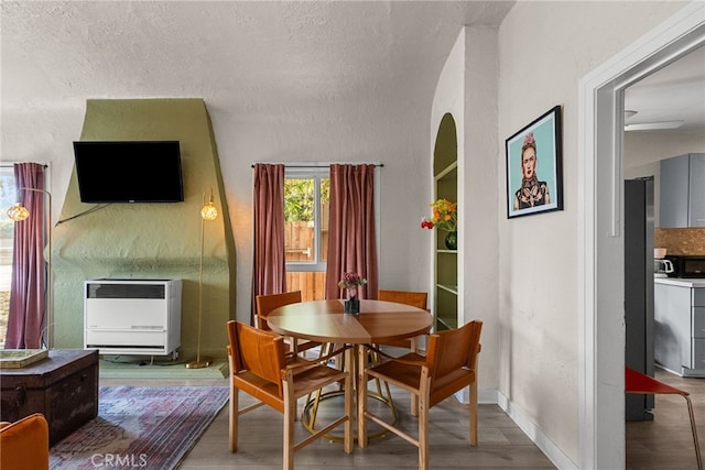 dining area featuring heating unit and hardwood / wood-style floors