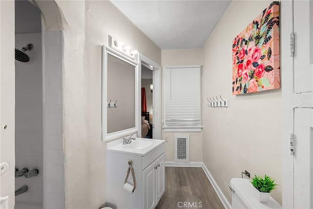 bathroom featuring wood-type flooring, vanity, and toilet