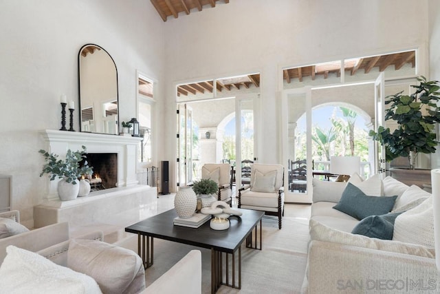 living room with a high ceiling and beam ceiling