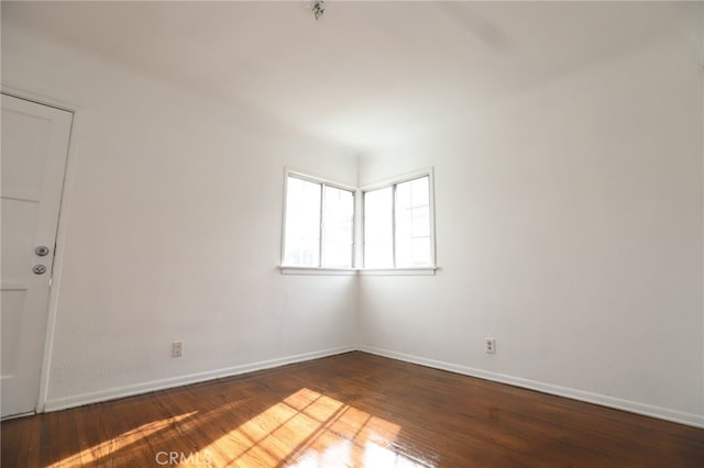 unfurnished room with dark wood-type flooring