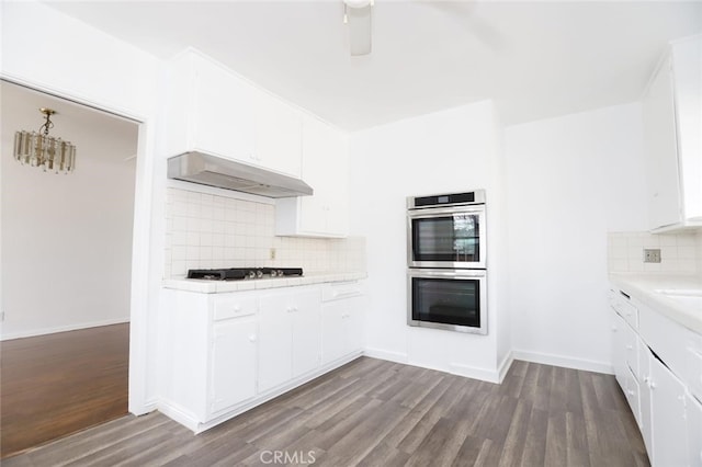 kitchen featuring gas stovetop, hardwood / wood-style floors, white cabinets, and double oven