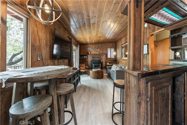 interior space with bar area, wood ceiling, light hardwood / wood-style flooring, and wood walls