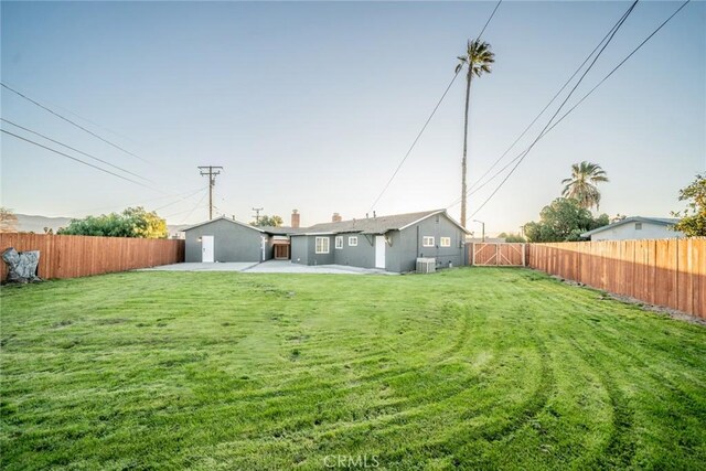 view of yard with central AC and a patio area