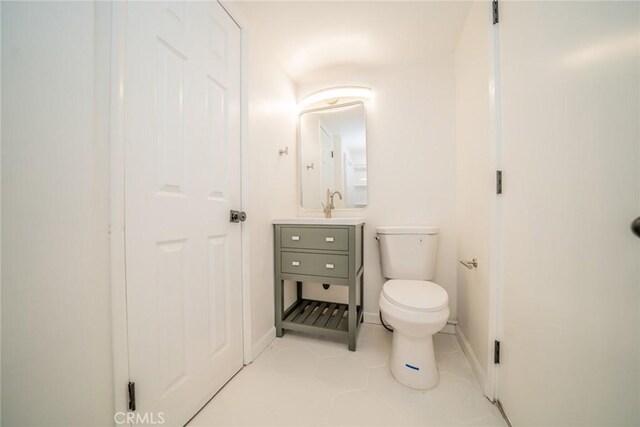 bathroom with tile patterned flooring, vanity, and toilet