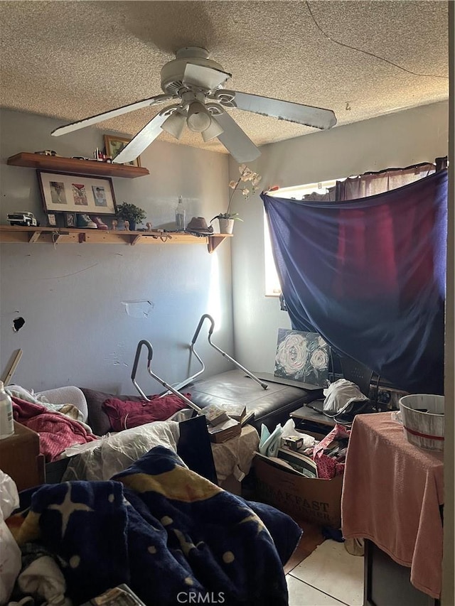 miscellaneous room with ceiling fan, a textured ceiling, and light tile patterned floors