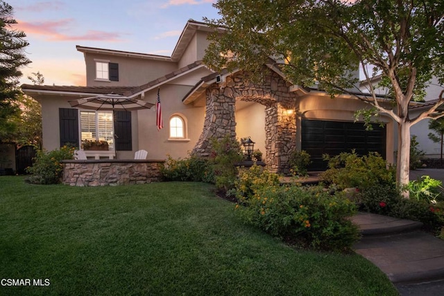 view of front of property featuring a garage and a lawn