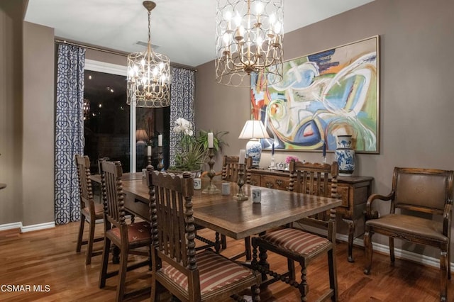 dining room with hardwood / wood-style flooring and a chandelier