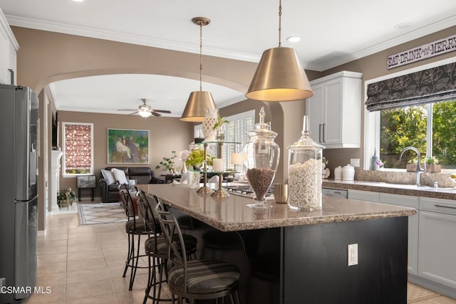 kitchen featuring white cabinetry, stainless steel fridge, hanging light fixtures, and light tile patterned floors