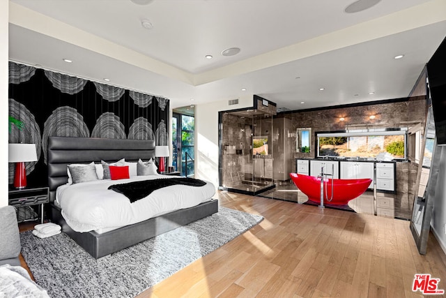 bedroom featuring multiple windows and hardwood / wood-style floors