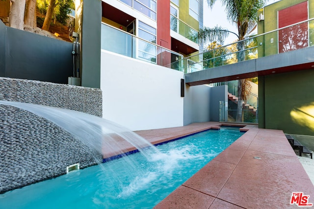 view of swimming pool with pool water feature