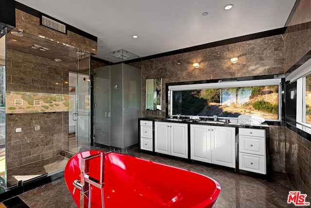 bathroom with vanity, separate shower and tub, and tile walls