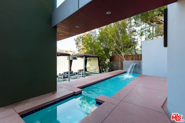 view of pool with pool water feature, an outdoor living space, and a patio area