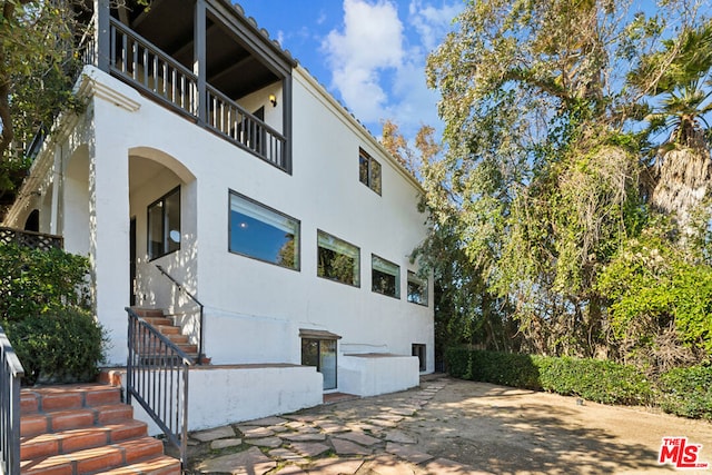 view of side of home featuring a balcony