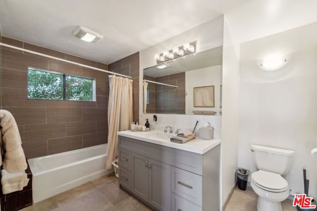 full bathroom featuring shower / bath combination with curtain, tile patterned floors, toilet, and vanity