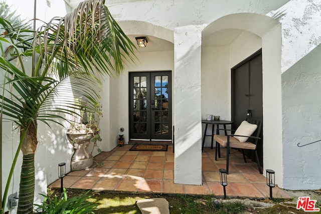 view of exterior entry with a patio area and french doors