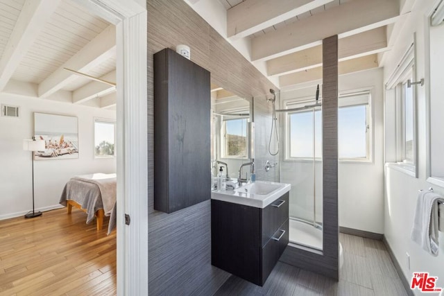 bathroom with a shower with door, vanity, hardwood / wood-style flooring, and beam ceiling