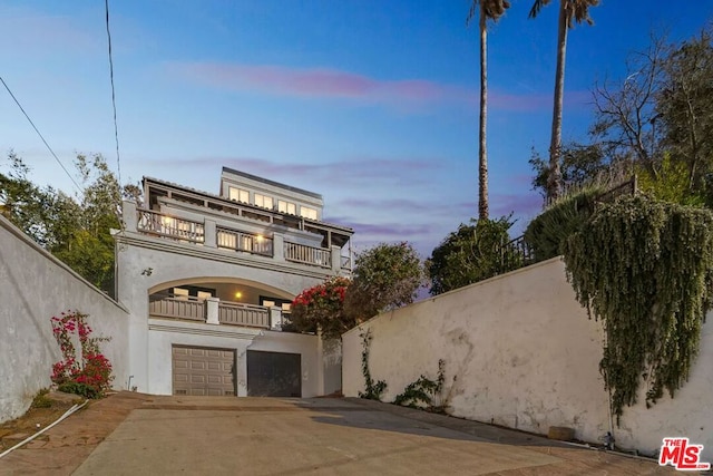 view of front of property with a garage and a balcony