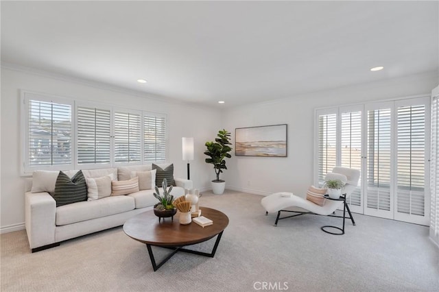 carpeted living room featuring ornamental molding