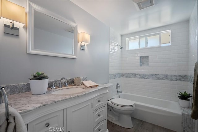 full bathroom with vanity, toilet, tiled shower / bath combo, and wood-type flooring