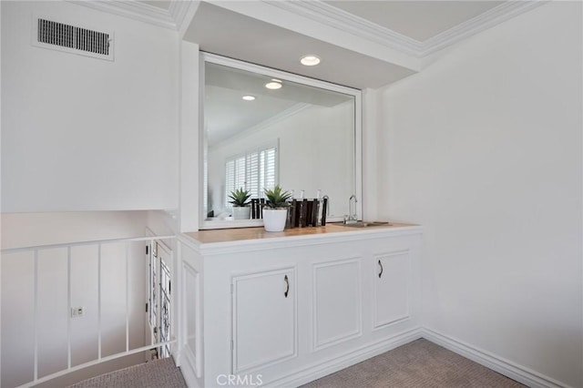 bar featuring crown molding, carpet floors, and sink