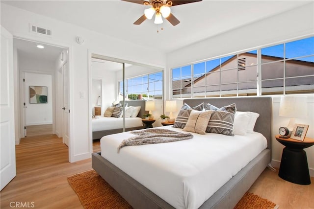 bedroom featuring light hardwood / wood-style floors, a closet, and ceiling fan