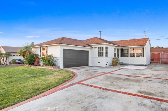 ranch-style house featuring a garage and a front yard