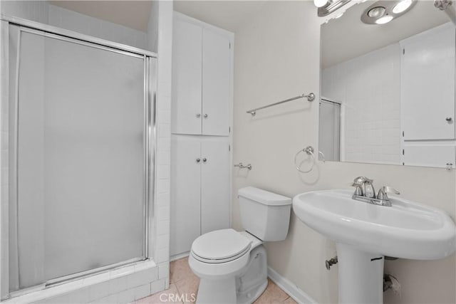 bathroom with tile patterned flooring, a shower with shower door, and toilet