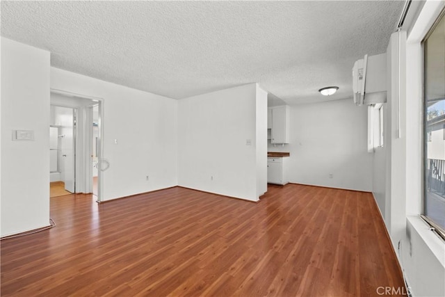 unfurnished room with wood-type flooring and a textured ceiling