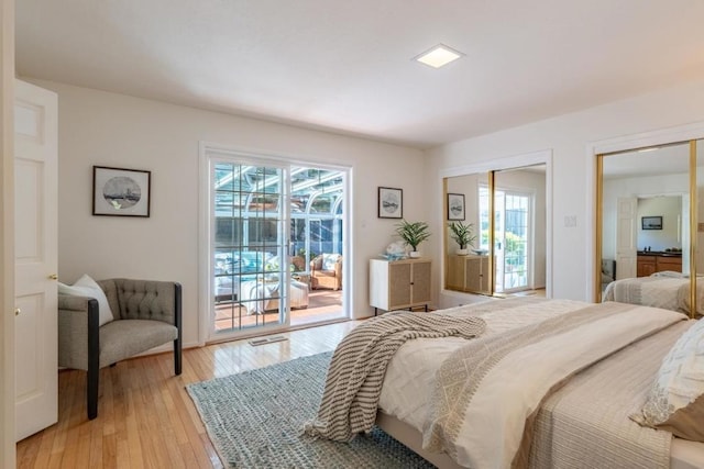 bedroom featuring multiple windows, access to exterior, and light hardwood / wood-style floors