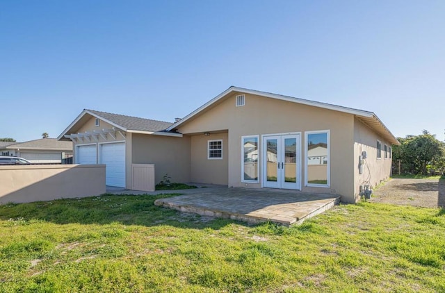 rear view of property with a yard, a patio area, and french doors