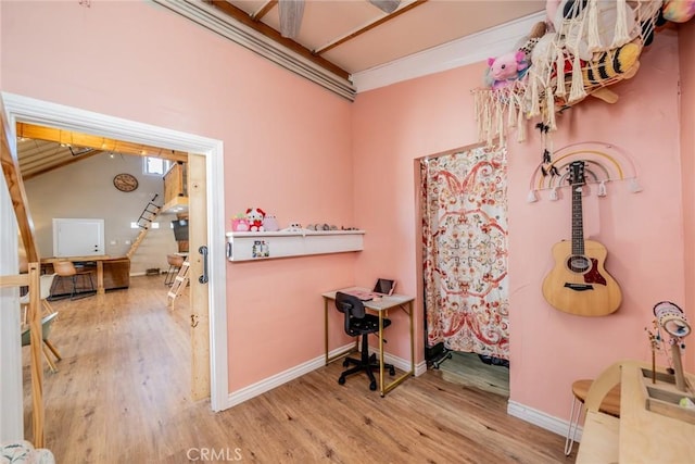 miscellaneous room featuring wood-type flooring and vaulted ceiling