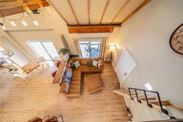 living room with beamed ceiling, high vaulted ceiling, and hardwood / wood-style flooring