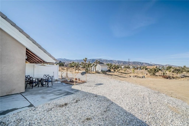 view of yard featuring a patio and a mountain view