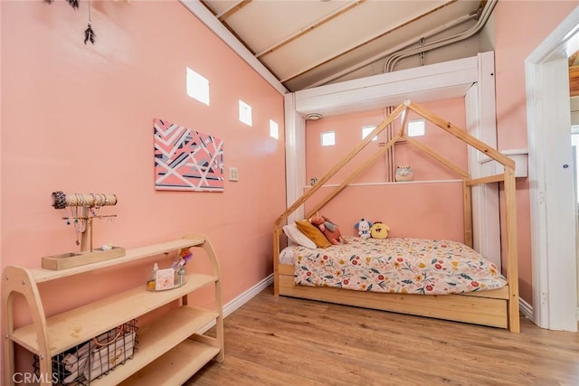 bedroom featuring vaulted ceiling and hardwood / wood-style floors