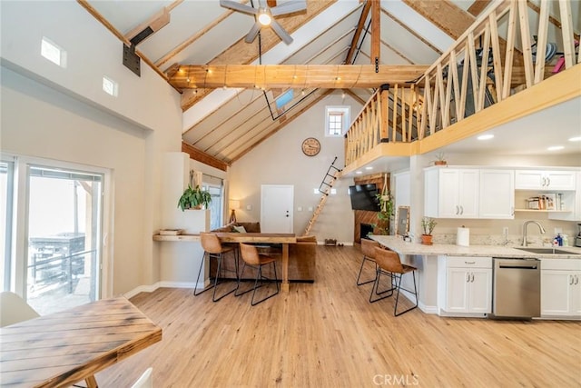 kitchen featuring high vaulted ceiling, beamed ceiling, white cabinetry, sink, and stainless steel dishwasher