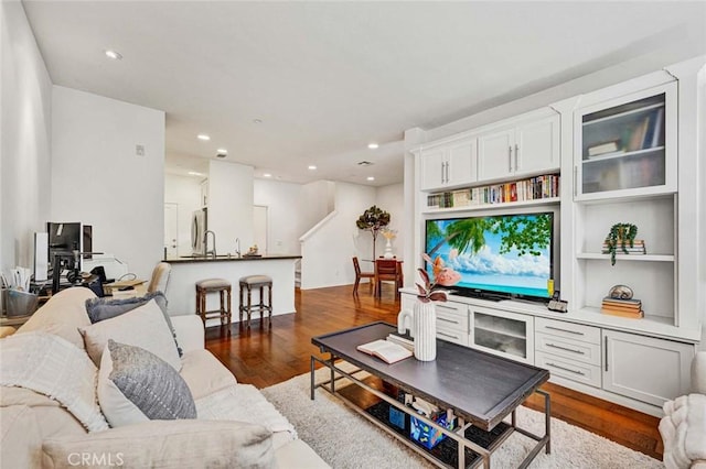 living room with dark hardwood / wood-style flooring and sink