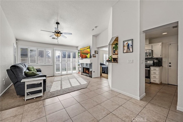 tiled living room featuring ceiling fan and a textured ceiling