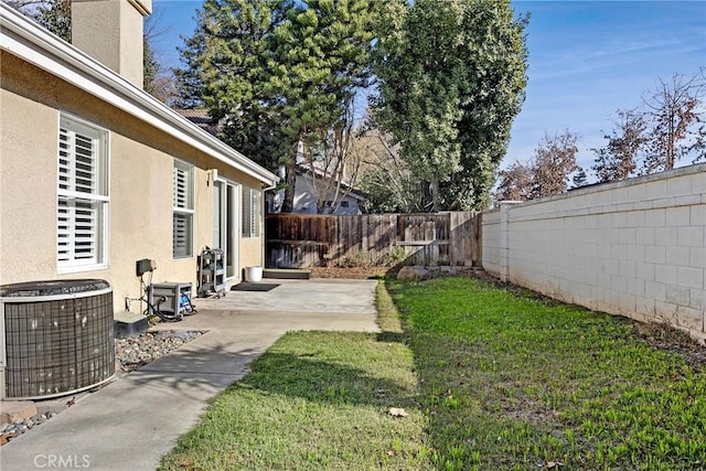 view of yard with central AC unit and a patio area