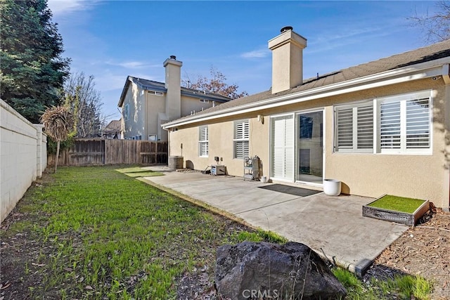 rear view of property featuring central AC, a lawn, and a patio area