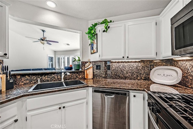 kitchen with stainless steel appliances, sink, white cabinets, and ceiling fan