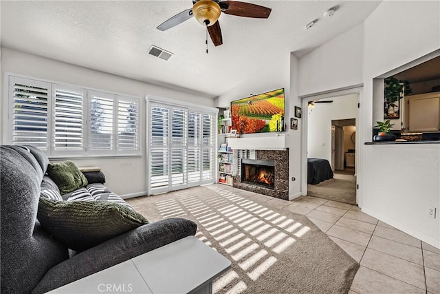 tiled living room with lofted ceiling, a textured ceiling, and ceiling fan