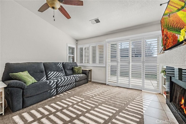 living room with light tile patterned floors, vaulted ceiling, and ceiling fan